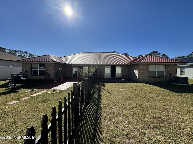 ranch-style house featuring a front yard and cooling unit