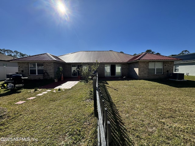 ranch-style home featuring central AC and a front yard