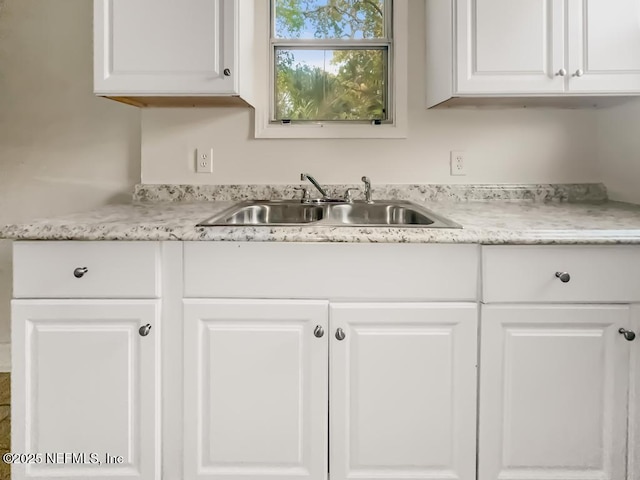 kitchen with white cabinetry and sink