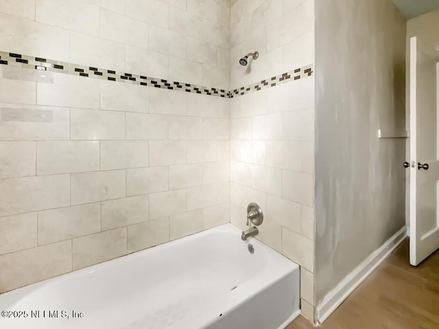 bathroom with tiled shower / bath combo and wood-type flooring