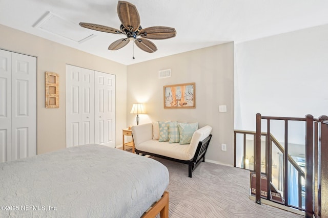 bedroom featuring ceiling fan, multiple closets, and carpet