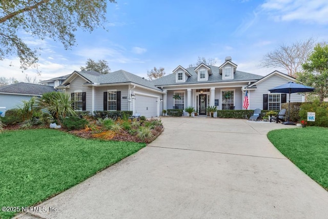 cape cod-style house featuring a garage, a porch, and a front yard