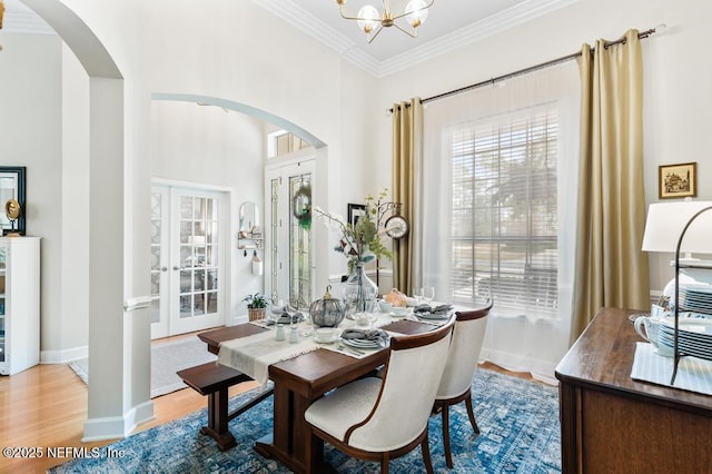 dining room with ornamental molding, hardwood / wood-style floors, and an inviting chandelier