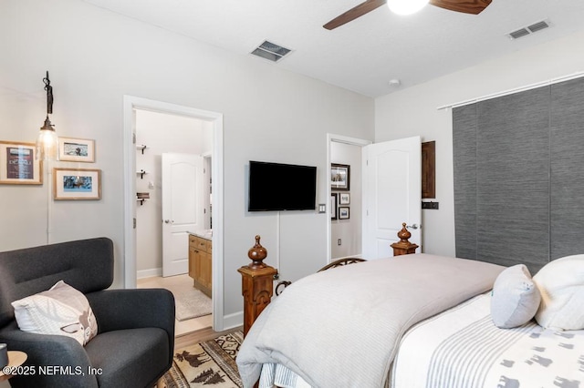 bedroom with ceiling fan, ensuite bath, and light wood-type flooring