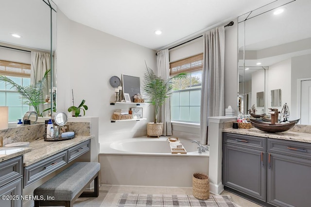 bathroom featuring tile patterned flooring, vanity, and a bathing tub