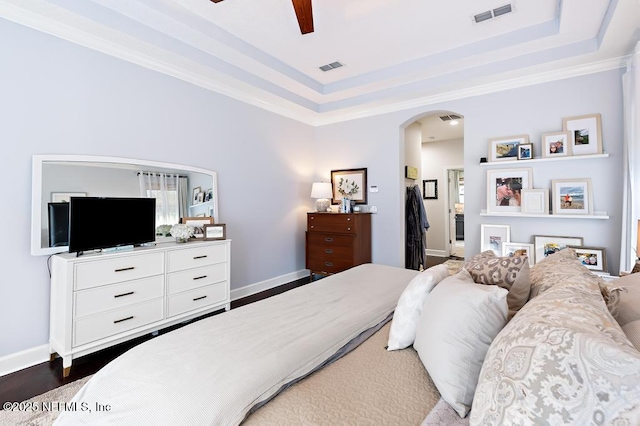 bedroom featuring dark wood-type flooring, ceiling fan, and a raised ceiling