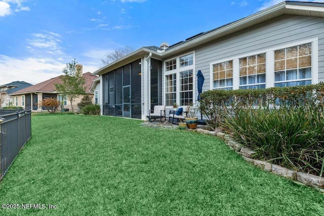 back of house featuring a yard and a sunroom