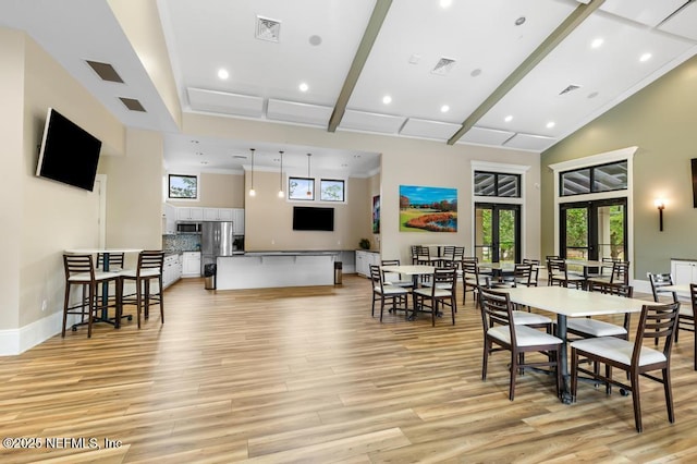 dining area featuring light hardwood / wood-style floors, ornamental molding, high vaulted ceiling, and french doors