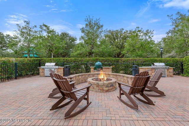 view of patio / terrace with a grill, exterior kitchen, and a fire pit