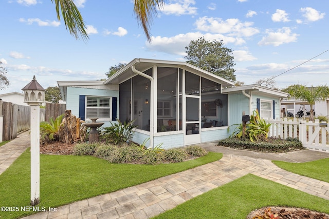 view of front facade with a sunroom and a front yard