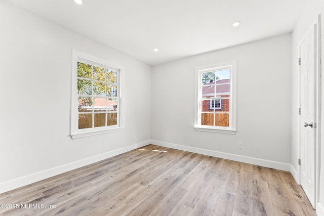 spare room with a wealth of natural light and light wood-type flooring