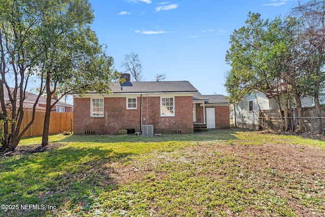 rear view of property with a yard and cooling unit