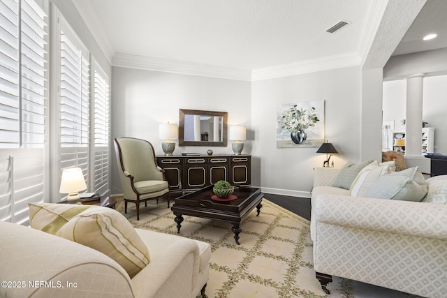 living room with hardwood / wood-style floors, crown molding, and decorative columns