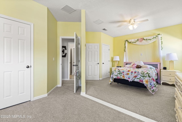 carpeted bedroom featuring ceiling fan and a textured ceiling