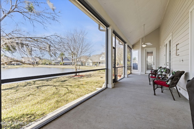 sunroom featuring a water view and lofted ceiling