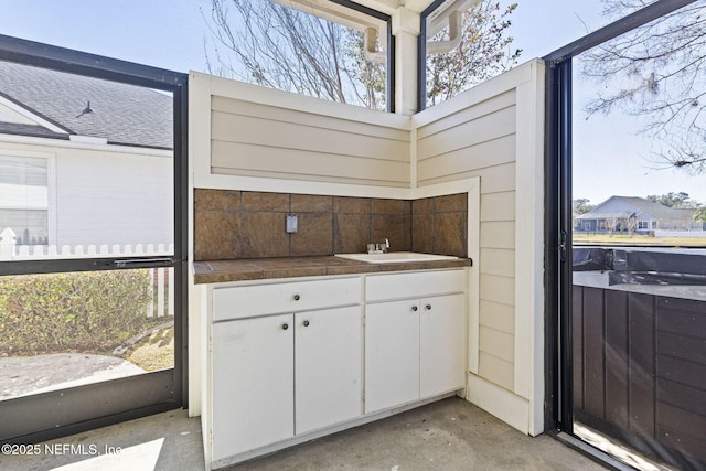 interior space featuring a healthy amount of sunlight, sink, and white cabinets