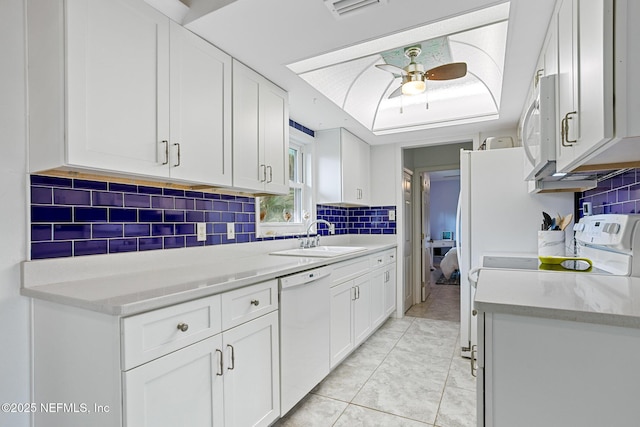 kitchen with white cabinetry, white appliances, and sink