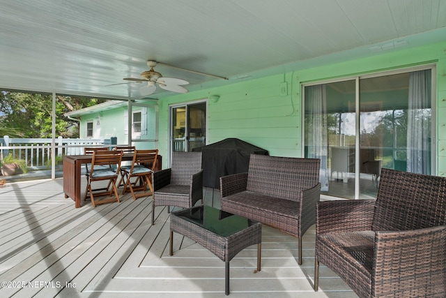 wooden deck featuring grilling area, outdoor lounge area, and ceiling fan