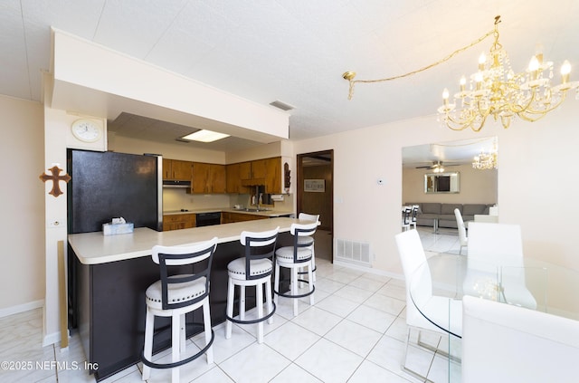 kitchen featuring sink, a breakfast bar area, fridge, kitchen peninsula, and ceiling fan