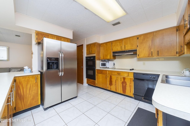 kitchen featuring sink, light tile patterned floors, and black appliances