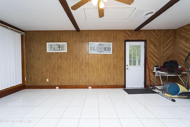 spare room featuring beamed ceiling, ceiling fan, and wood walls