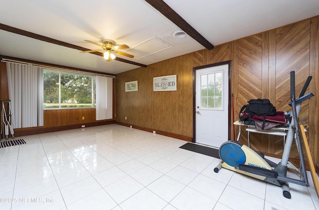 exercise room featuring ceiling fan, wood walls, and light tile patterned floors