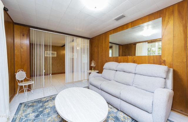 living room with wooden walls and light tile patterned floors