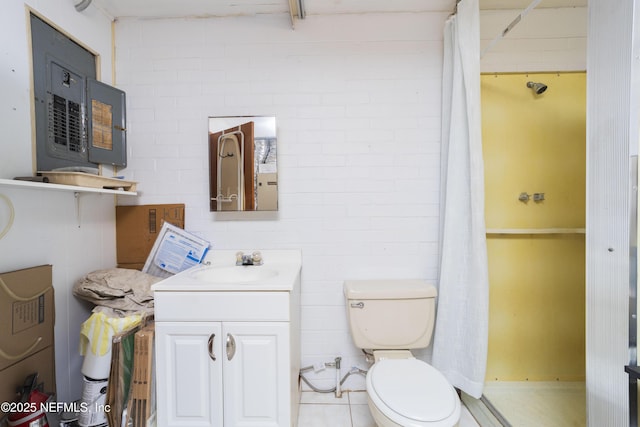 bathroom featuring a shower with curtain, brick wall, vanity, and toilet