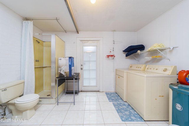 washroom featuring light tile patterned floors and washing machine and clothes dryer