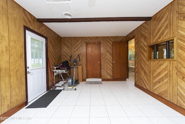 tiled foyer featuring wooden walls and beam ceiling