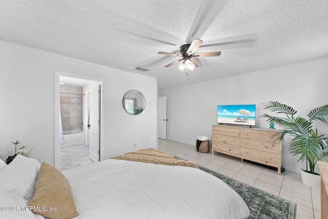 bedroom featuring light tile patterned floors, visible vents, connected bathroom, ceiling fan, and a textured ceiling