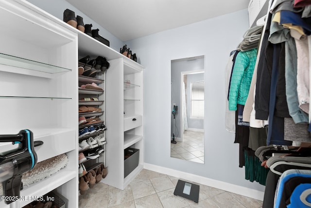 walk in closet with light tile patterned floors