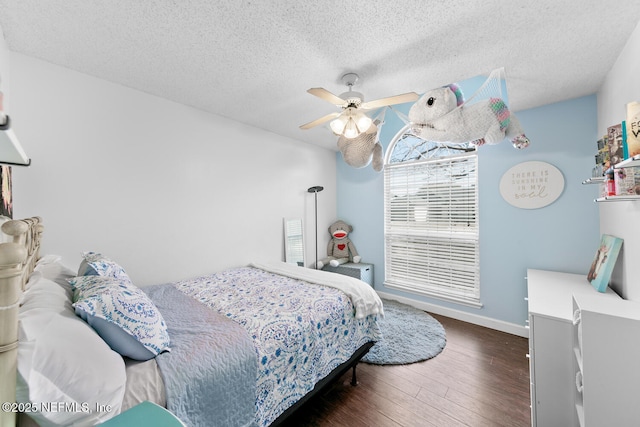 bedroom featuring a textured ceiling, a ceiling fan, and dark wood-type flooring