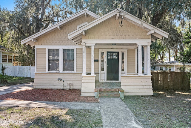 bungalow featuring fence and a porch