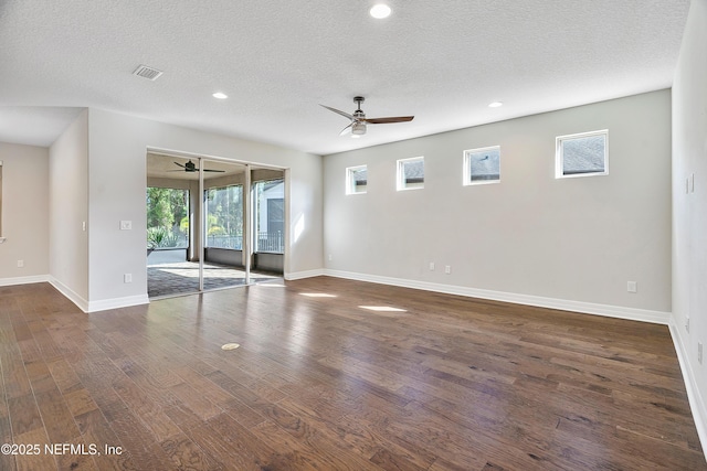 spare room with ceiling fan, dark hardwood / wood-style floors, and a textured ceiling