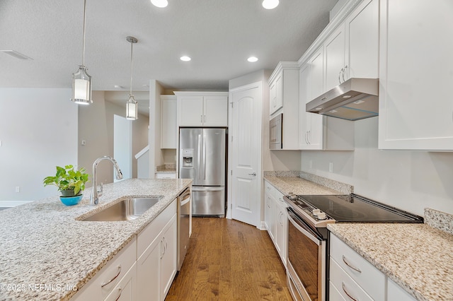 kitchen with decorative light fixtures, white cabinetry, sink, light stone counters, and stainless steel appliances