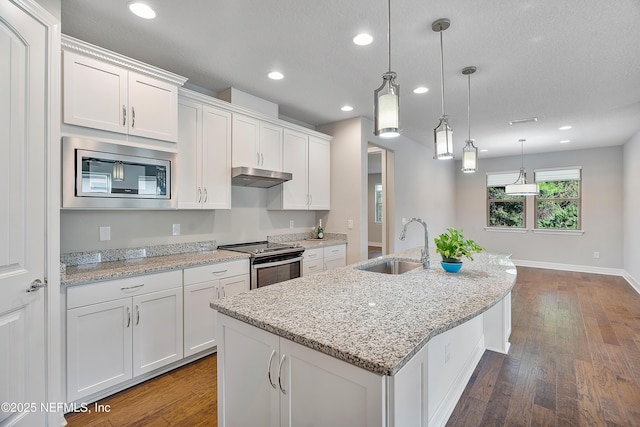 kitchen with white cabinetry, decorative light fixtures, an island with sink, and appliances with stainless steel finishes