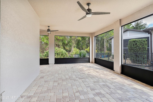 unfurnished sunroom with ceiling fan