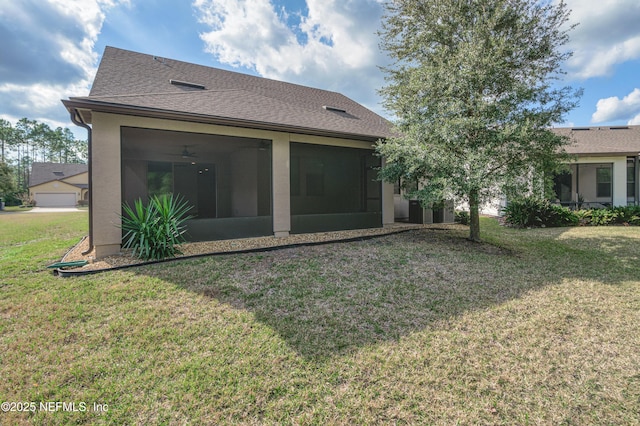 rear view of house with ceiling fan, a yard, and a sunroom