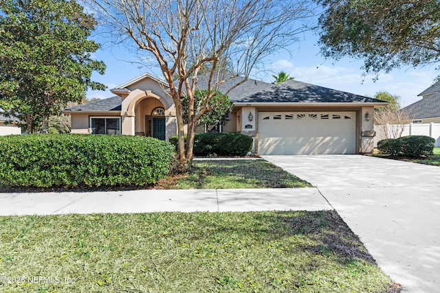 ranch-style home featuring an attached garage, fence, concrete driveway, and stucco siding