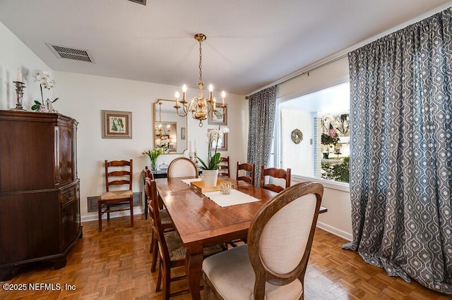 dining room with an inviting chandelier and parquet flooring