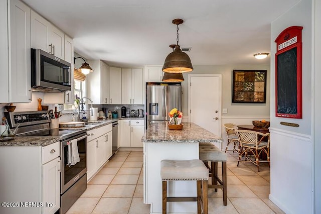 kitchen featuring stainless steel appliances, a center island, and white cabinets