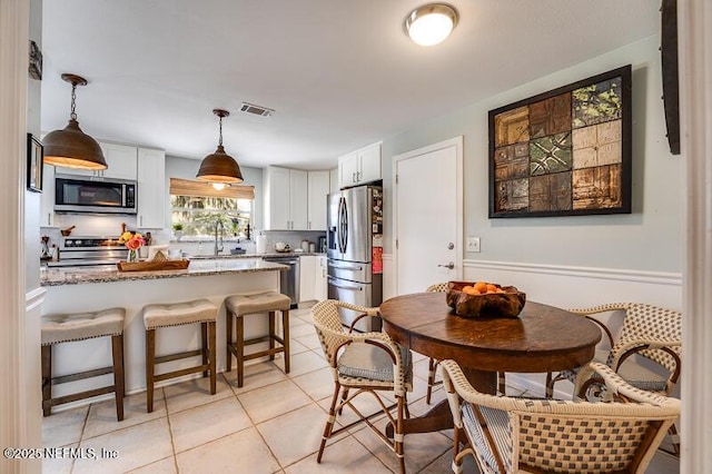 tiled dining room featuring sink