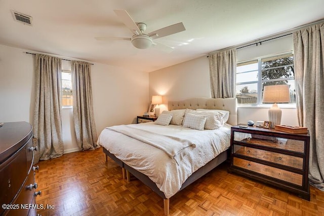 bedroom with ceiling fan and parquet flooring