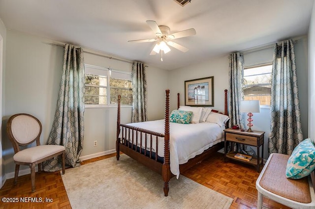 bedroom featuring multiple windows, parquet flooring, and ceiling fan