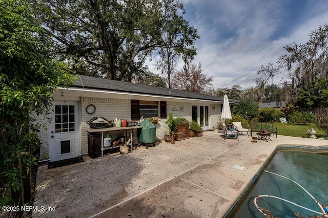 rear view of house with a fire pit and a patio