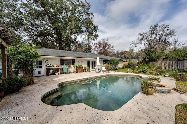 view of swimming pool with a hot tub and a patio area