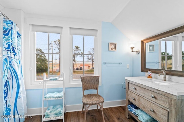 bathroom featuring vanity, hardwood / wood-style floors, and vaulted ceiling