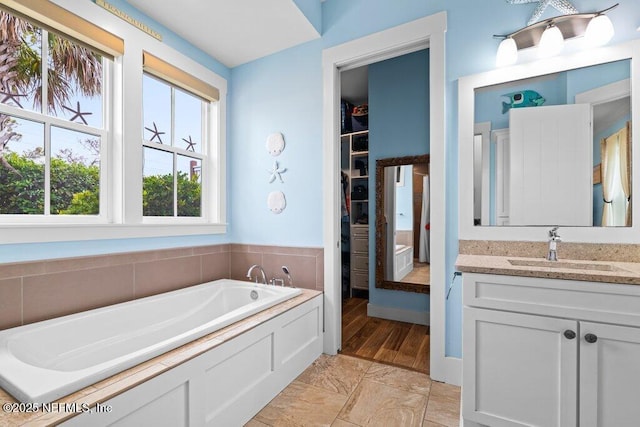 bathroom with a tub to relax in and vanity