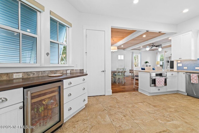 kitchen featuring white cabinetry, appliances with stainless steel finishes, wine cooler, and beam ceiling